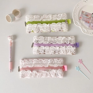 Vue détaillée de trousses à fleurs matelassées vertes, mauves et roses avec dentelle