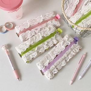 Détail des trousses à dentelle en teintes pastel rose, vert et violet pour école