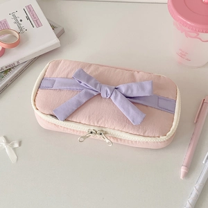 Detail of pink nylon pencil case with purple ribbon bow and smooth double metal zippers