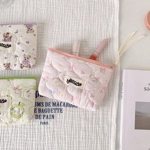 Detailed close-up of quilted cotton storage pouches with cute bear and rabbit patterns