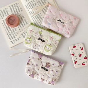 Close-up of quilted cotton mini pouches with cute bear patterns and woven brand labels