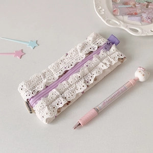Détail de la trousse à fleurs en dentelle avec fermeture éclair violette et volants