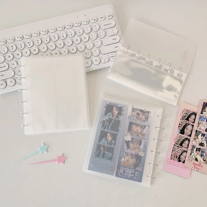 Frosted disc-bound photocard binder with internal PP sleeves on mechanical keyboard