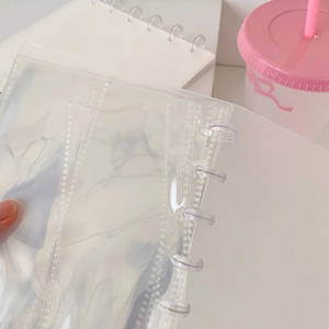Close-up of clear PVC loose-leaf photo album cover with mushroom binder rings for photocard storage