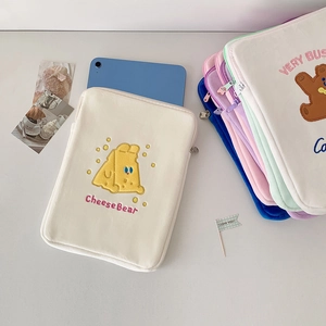 Close-up of plush tablet sleeve featuring cute cheese bear embroidery and soft texture