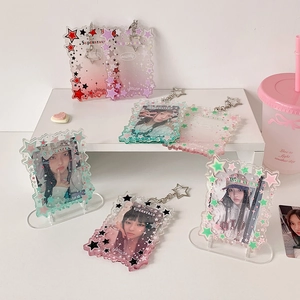 Star-themed gradient acrylic photocard holders and keychains display on white stand