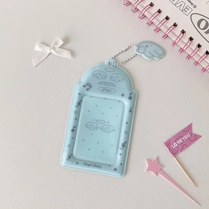 Close-up of light blue angel wing PVC photocard holder with star and music note patterns