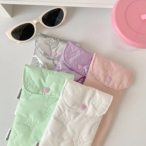 Detailed macro view of quilted bow-patterned pouches in pastel macaron colors with heart buttons