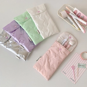 Quilted bow pencil case in silver, purple, green, white, and pink with heart button closure