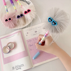 Close-up of creative plush ball pens with heart sunglasses and macaron beads inside