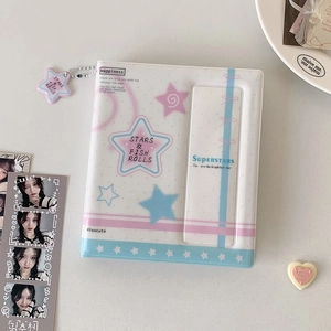 Detailed close-up of a K-pop photocard album with star pendant and pastel cover design