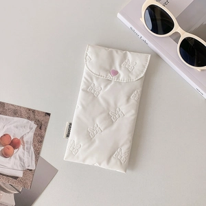 Detailed view of white quilted storage bag with butterfly texture and pink heart button