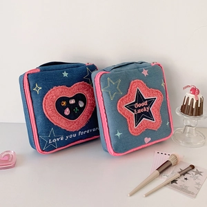 Detail of denim cosmetic bags with pink heart and star plush embroidery and rhinestones