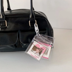 Close-up of clear PVC photo card holders with heart pattern and white clips on a black bag