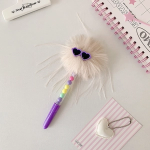 Détail d'un stylo à pompon avec lunettes coeur et perles arc-en-ciel colorées