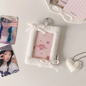 Detail of white plush pillow photo card holder with bows and silver keychain hook
