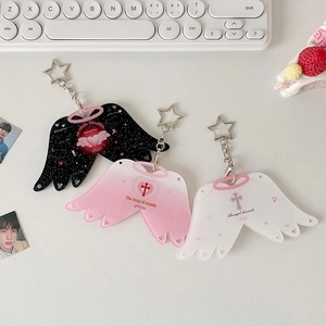 Detailansicht von drei Acryl-Flügel-Schlüsselanhängern in Schwarz, Rosa und Weiß