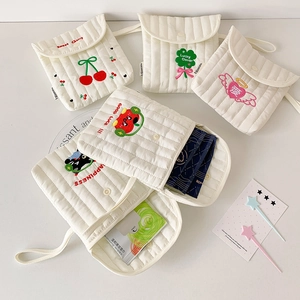 Detail of cream quilted cotton storage bags with embroidered cherry and clover patterns