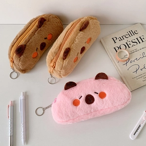 Close-up of soft plush pencil cases with embroidery and zipper in three colors