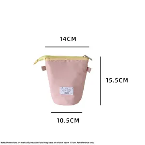 Pink stand-up pencil case with cartoon eyes, showing dimensions 14x10.5x15.5cm