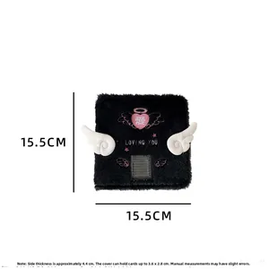 Detail view of plush black photocard holder with angel wings and heart embroidery