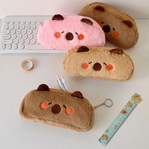 Detailed view of plush capybara pencil cases in pink and brown on a study desk setup