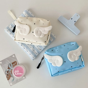 Detail of mini wing pouches in cream and blue with star pattern for cosmetics