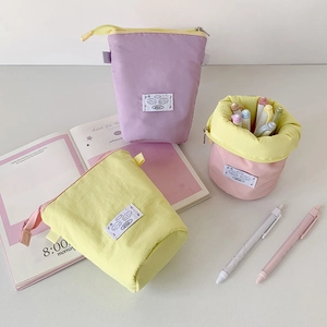 Macro detail of macaron-colored telescopic pencil case standing on a desk