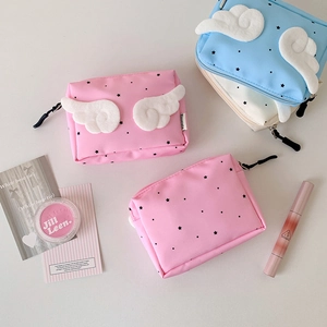 Detailed view of mini cosmetic bags featuring plush wings and black star patterns