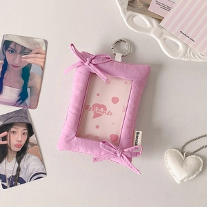 Detailed view of pink plush photocard holder with metal ring and bow decorations
