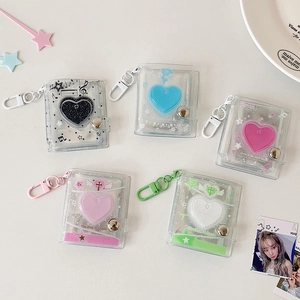 Detailed flat lay of colorful 2-inch mini photo albums with heart accents and keychains