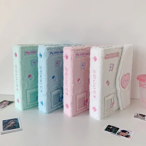 Macro shot of fluffy plush photo binders in pastel colors with cute cartoon embroidery