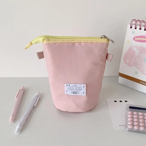 Vertical pink canvas stationery pouch with yellow zipper and cute cartoon patch detail