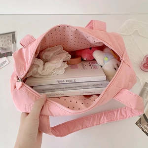 Pink bow-textured tote bag with heart zipper and polka dot lining in a cute setting