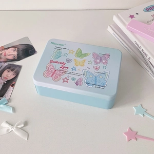 Close-up of light blue tin box featuring colorful butterfly prints and Y2K star patterns