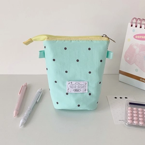 Detailed view of pale green polka dot pencil case with vertical storage and yellow zipper