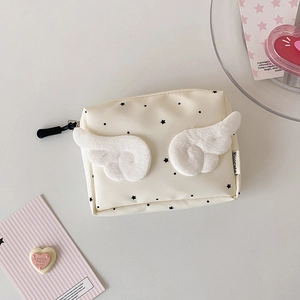 Close-up of mini canvas earphone bag with plush wings and star patterns