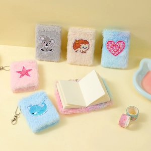 Detail of plush mini notebooks with cartoon embroidery and metal bead chain hangers