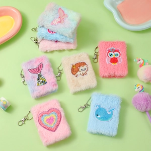 Detail of plush mini notebooks with colorful embroidery patches and silver keychains