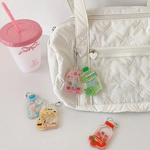 Cute acrylic drink bottle shakers with sequins on a white bag and pink cup