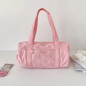 Close-up of pink bow quilted barrel bag featuring transparent pocket and heart zipper pull