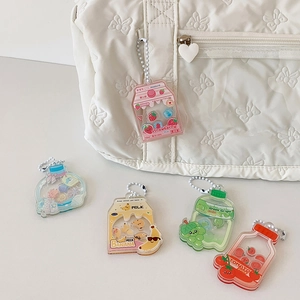 Close-up of cute acrylic fruit milk liquid charm attached to a white quilted handbag