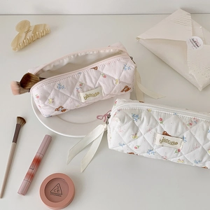 Flat lay of quilted cotton makeup bags with cute floral patterns and ribbon zippers