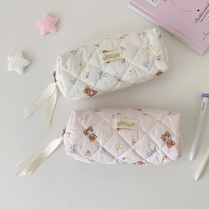 Quilted cosmetic bags with cute bear patterns and ribbon zipper pull displayed on desk