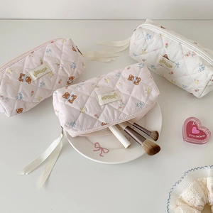 Detail of quilted cotton makeup bag with cute bear pattern and elegant ribbon zipper