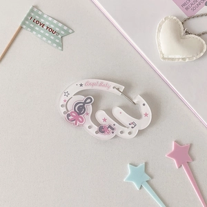 Close-up of Kawaii Angel Baby acrylic carabiner with cute pink patterns for backpacks
