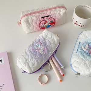 Close-up of quilted heart-patterned pencil bags with cute cartoon rabbit prints