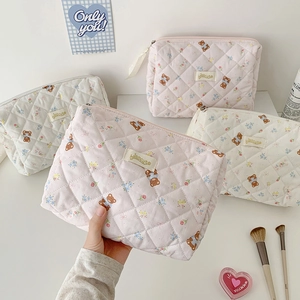 Quilted cartoon bear makeup bag with floral patterns and zipper closure in pastel colors