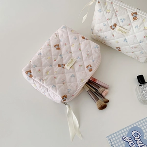 Quilted cosmetic bags with bear and floral patterns showing brushes inside