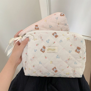Detail of quilted makeup bags with cute bear patterns and delicate ribbon zipper